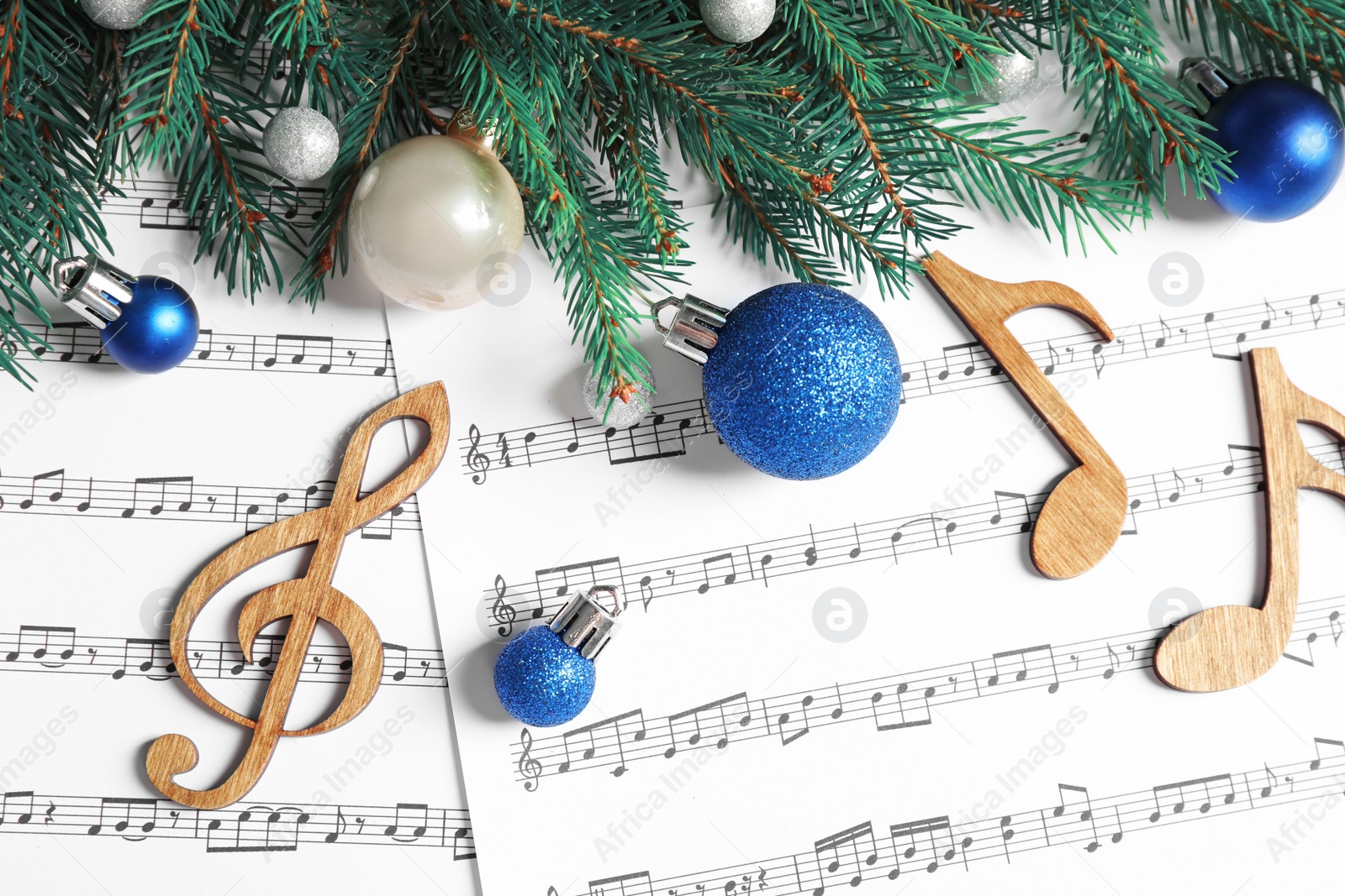 Photo of Flat lay composition with Christmas decorations and wooden music notes on sheets