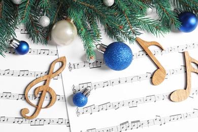 Photo of Flat lay composition with Christmas decorations and wooden music notes on sheets