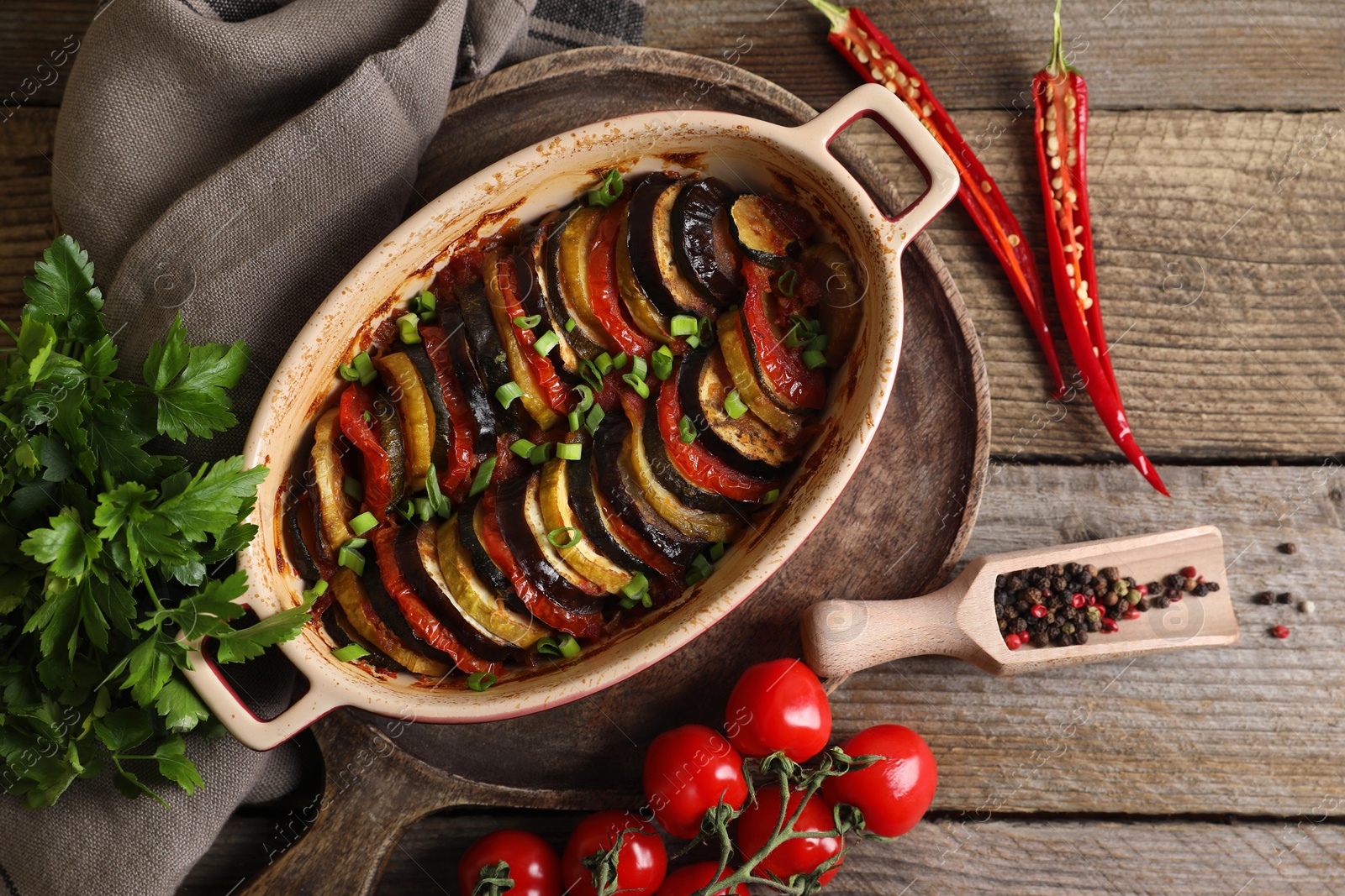 Photo of Delicious ratatouille and ingredients on wooden table, flat lay