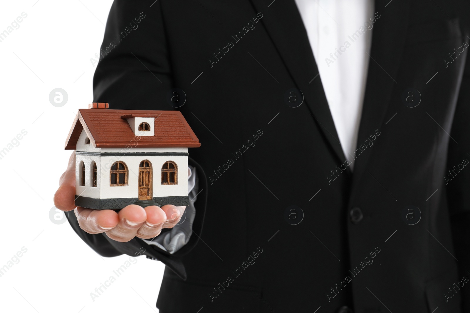 Photo of Real estate agent holding house model on white background, closeup