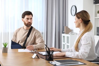 Photo of Injured man having meeting with lawyer in office