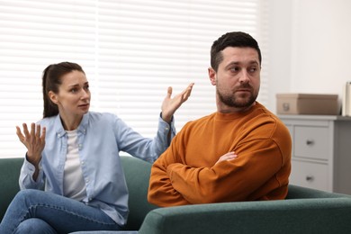 Offended husband ignoring his wife indoors. Relationship problems