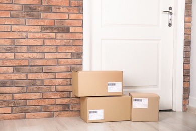 Cardboard parcel boxes on floor near apartment entrance. Mockup for design