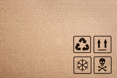 Image of Cardboard box with packaging symbols as background, closeup