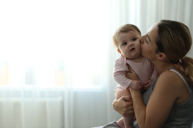 Photo of Young woman with her cute baby at home. Space for text
