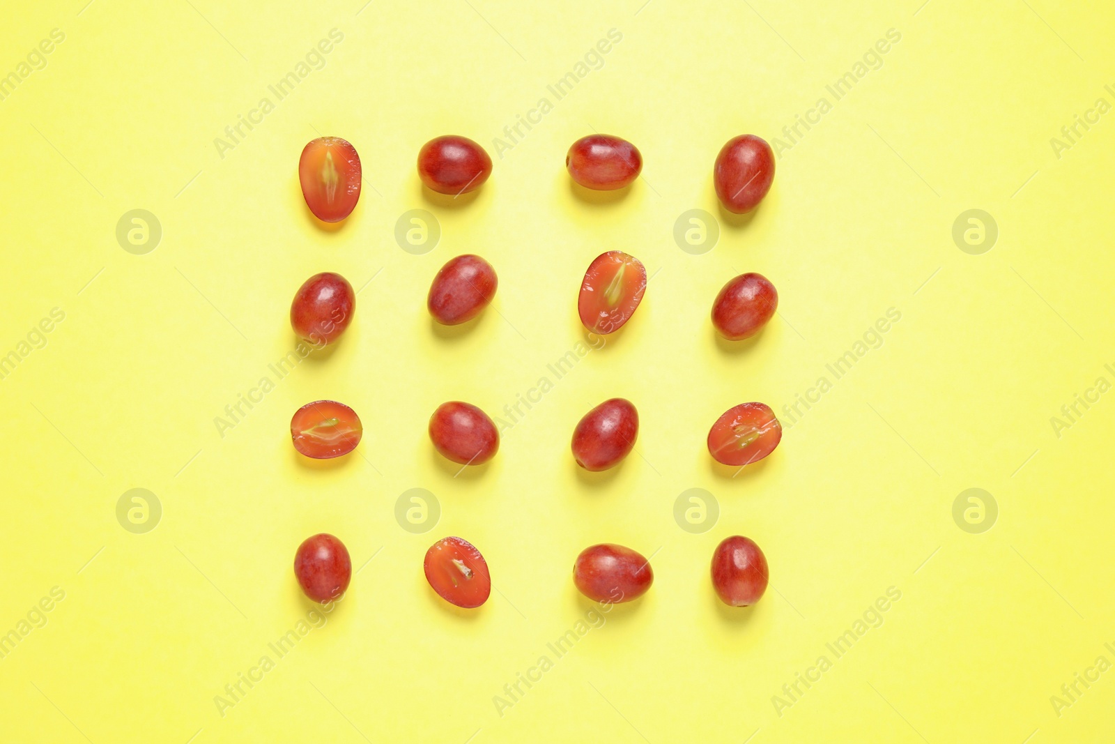 Photo of Flat lay composition with fresh ripe juicy grapes on yellow background