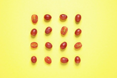 Photo of Flat lay composition with fresh ripe juicy grapes on yellow background