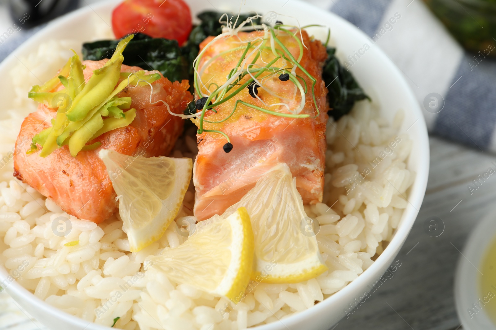 Photo of Tasty salmon with rice and spinach on white wooden table, closeup