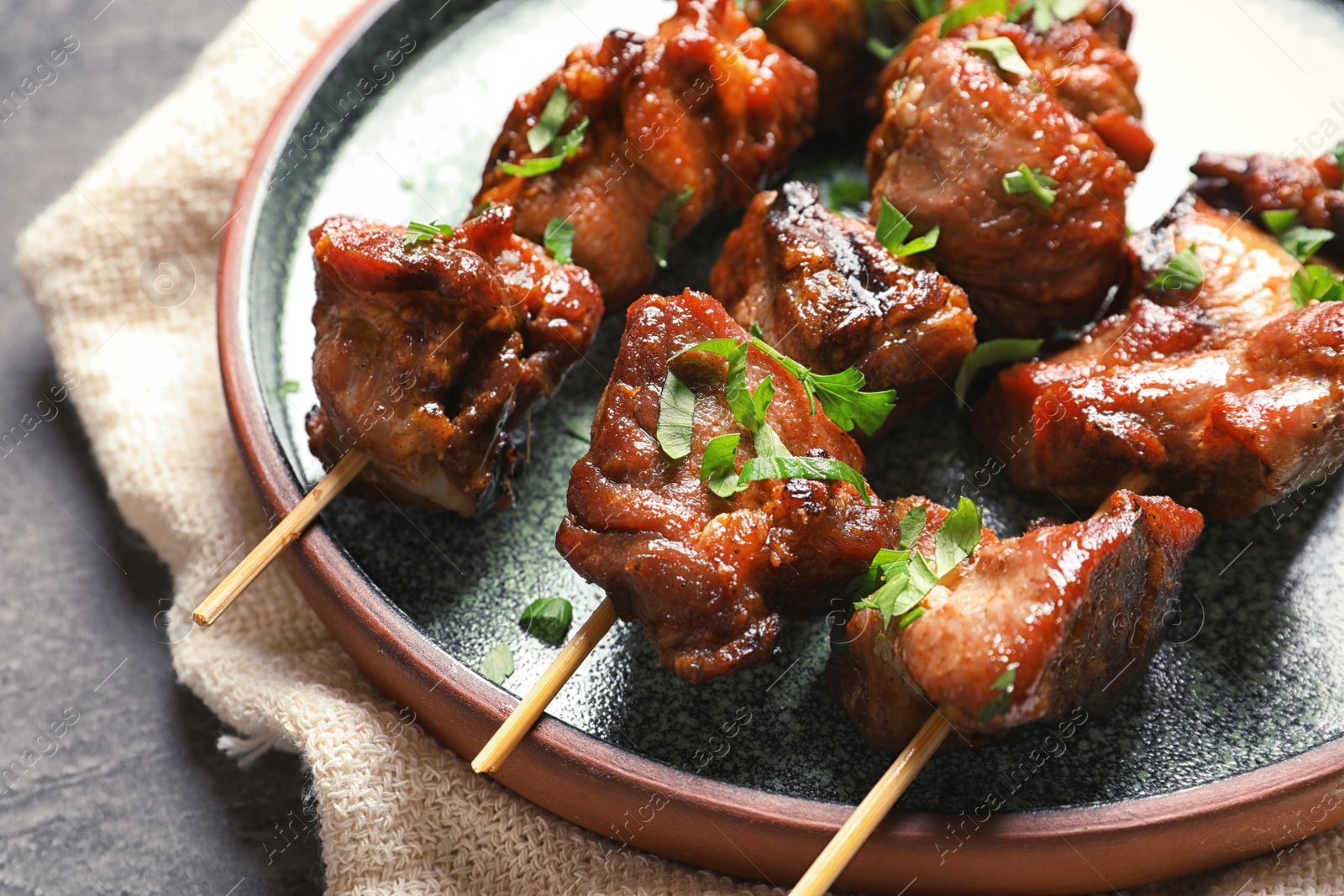 Photo of Plate with delicious meat served for barbecue party on gray table, closeup