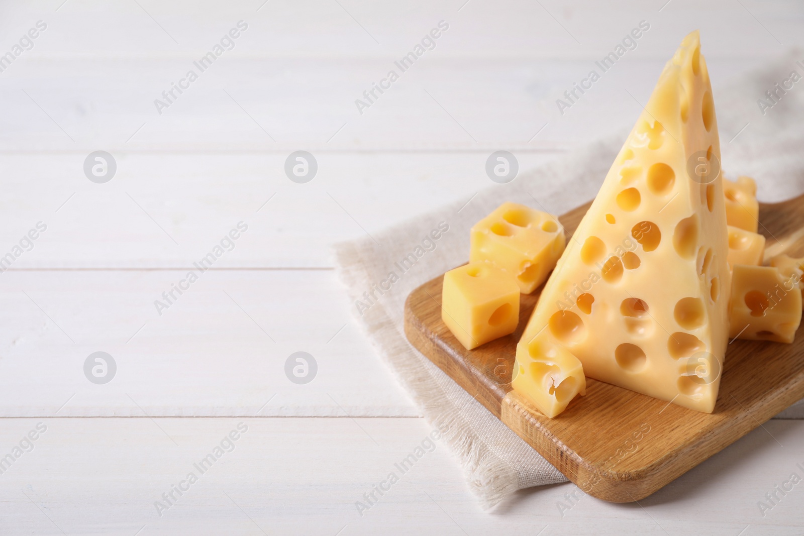 Photo of Tasty fresh cheese on white wooden table, space for text