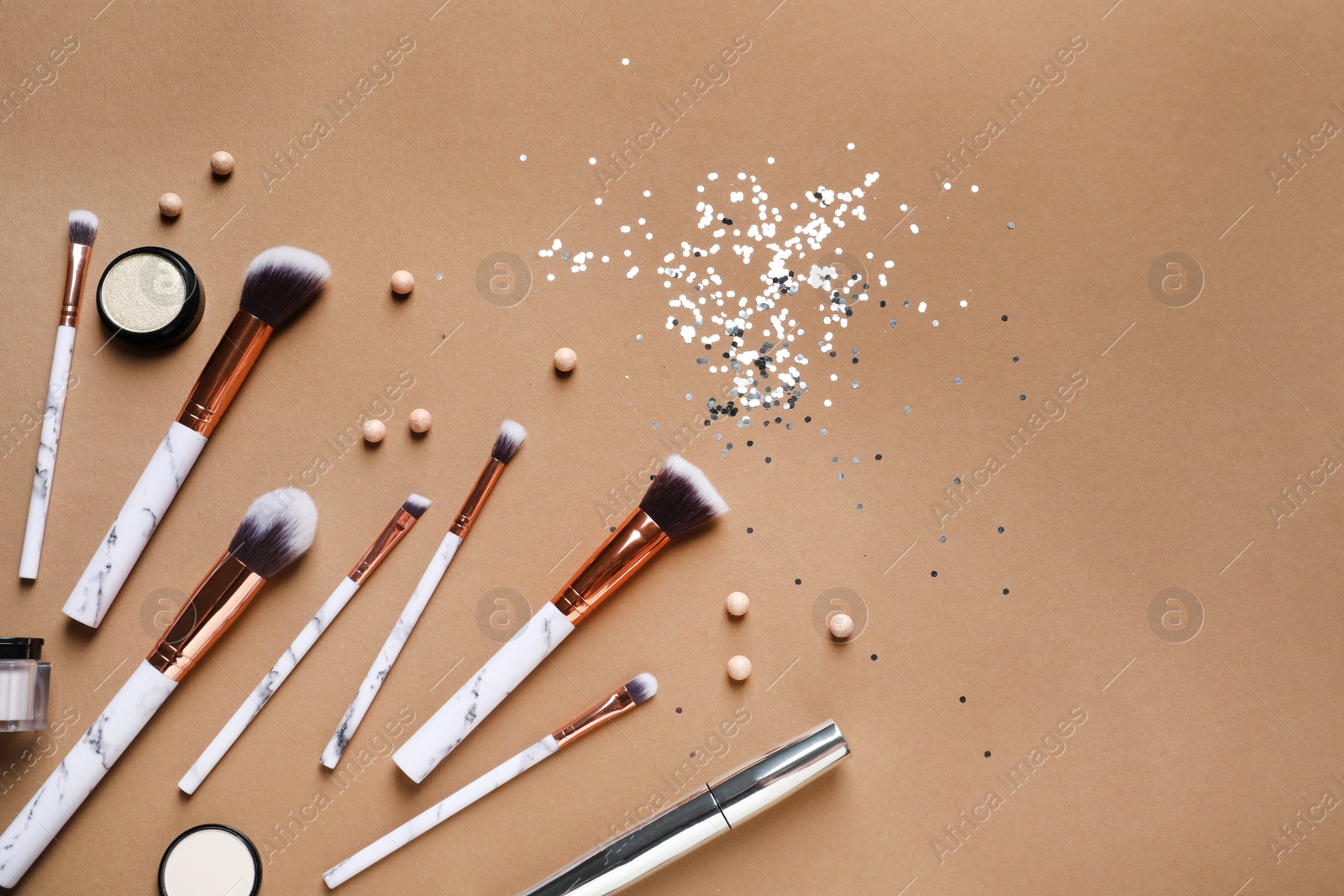 Photo of Flat lay composition with makeup brushes on brown background. Space for text