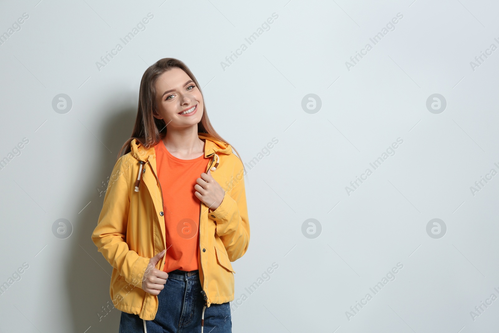 Photo of Young woman wearing blank t-shirt on light background. Mockup for design