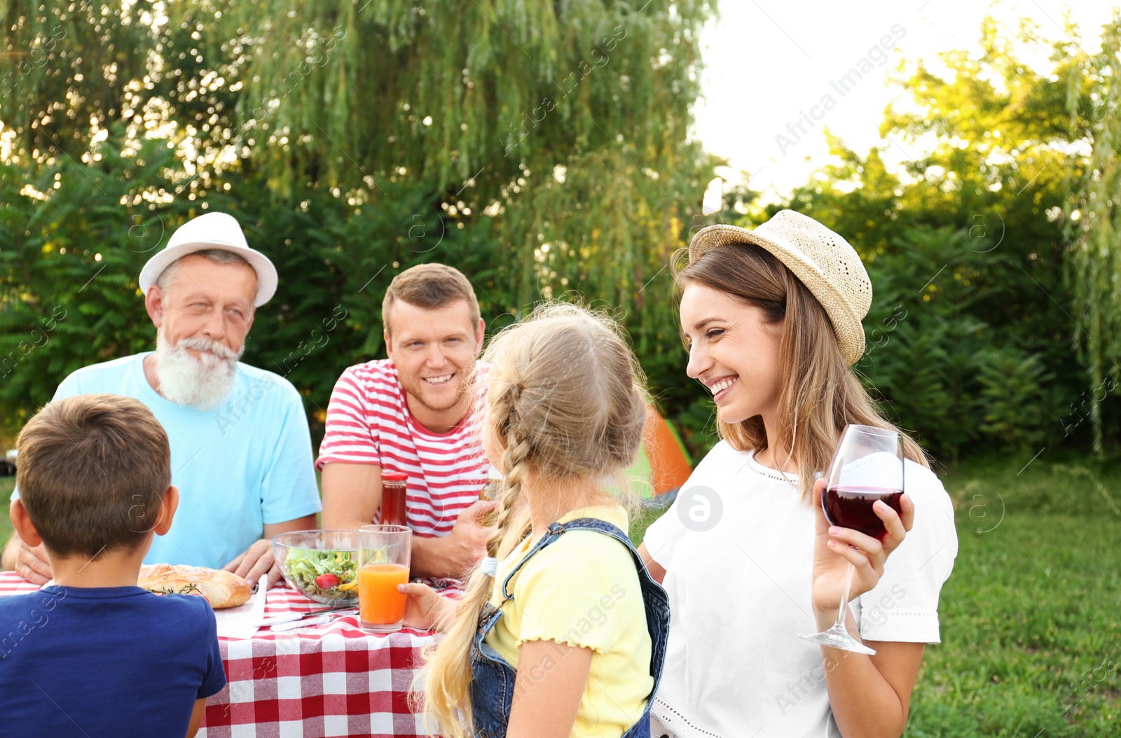 Photo of Happy family having barbecue in park on sunny day