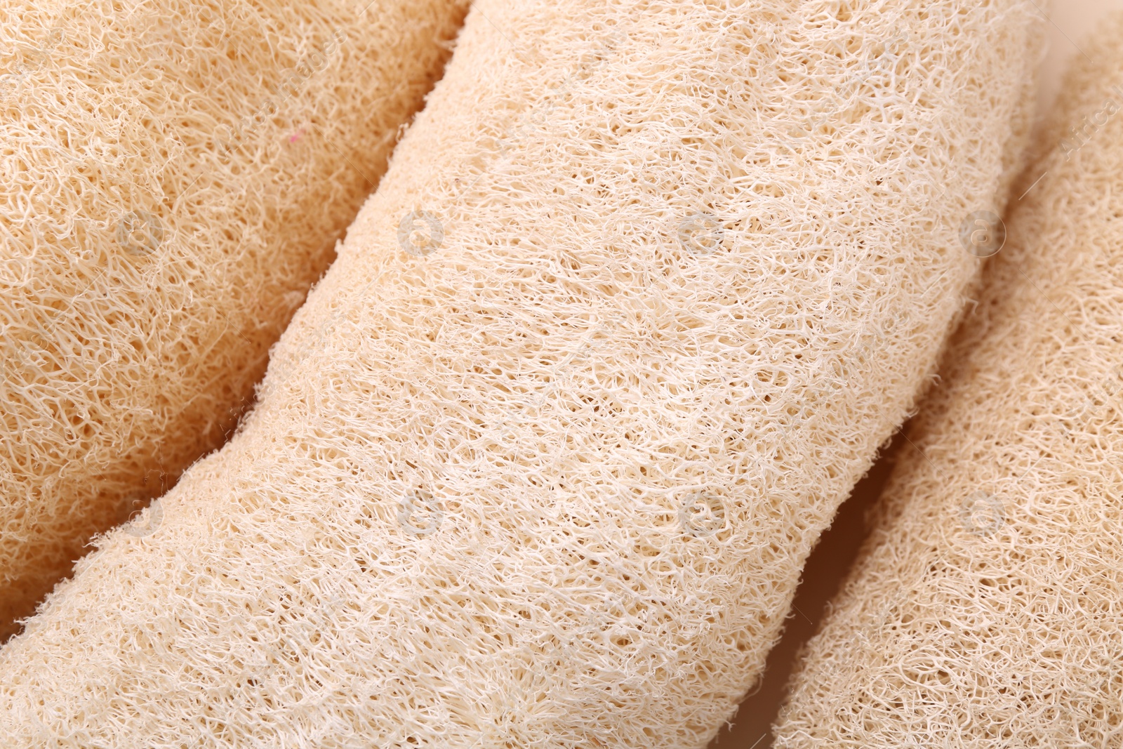 Photo of Natural loofah sponges as background, closeup view