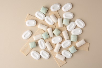 Many different chewing gums on beige background, flat lay