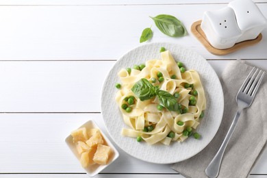 Photo of Delicious pasta with green peas served on white wooden table, flat lay. Space for text