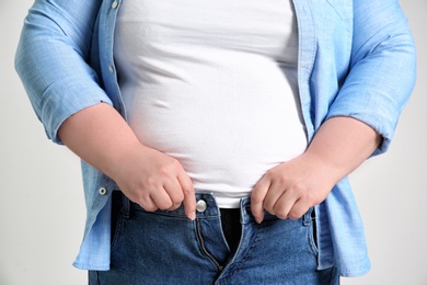 Overweight woman on light background