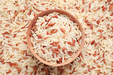 Mix of brown and polished rice with bowl, top view