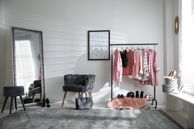 Dressing room interior with clothing rack and comfortable chair