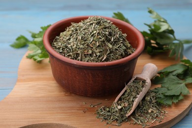 Photo of Dried parsley and fresh leaves on light blue table, closeup