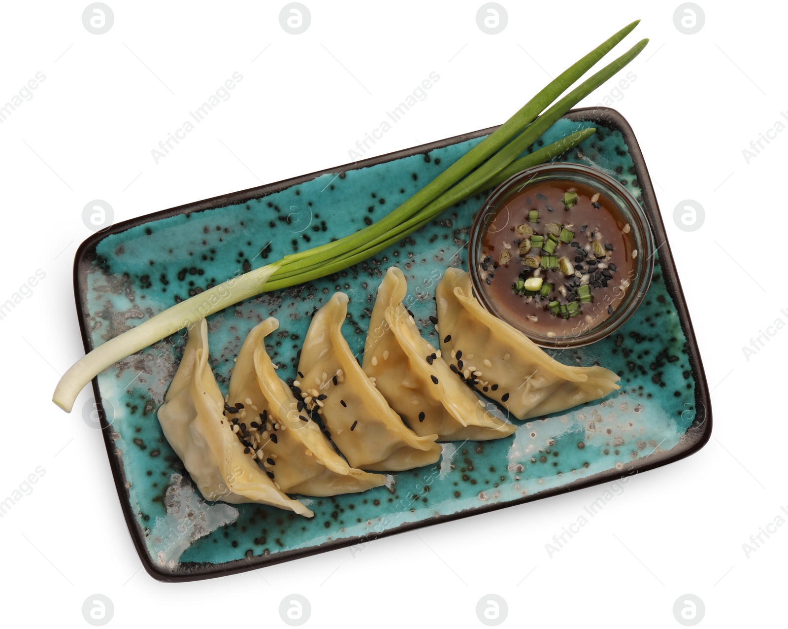 Photo of Delicious gyoza (asian dumplings) with sauce, onion and sesame isolated on white, top view