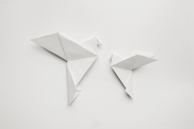 Photo of Beautiful origami birds on white background, flat lay