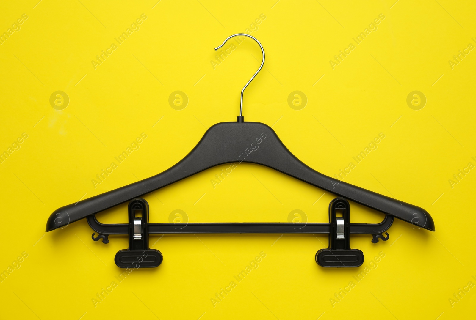 Photo of Empty hanger on yellow background, top view