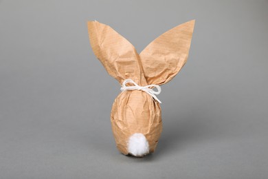 Photo of Easter bunny made of kraft paper and egg on grey background