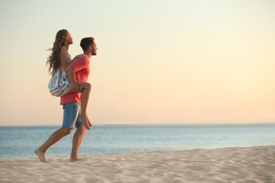 Photo of Happy young couple playing together on beach