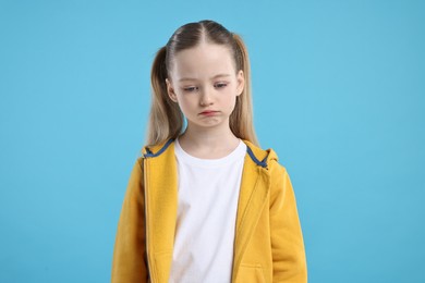 Photo of Portrait of sad girl on light blue background