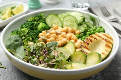 Healthy meal. Tasty vegetables and chickpeas in bowl on grey table, closeup