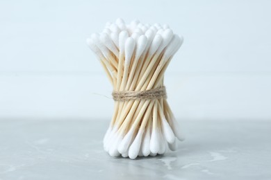 Many cotton buds on light grey marble table