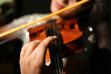 Woman playing violin at music lesson, closeup