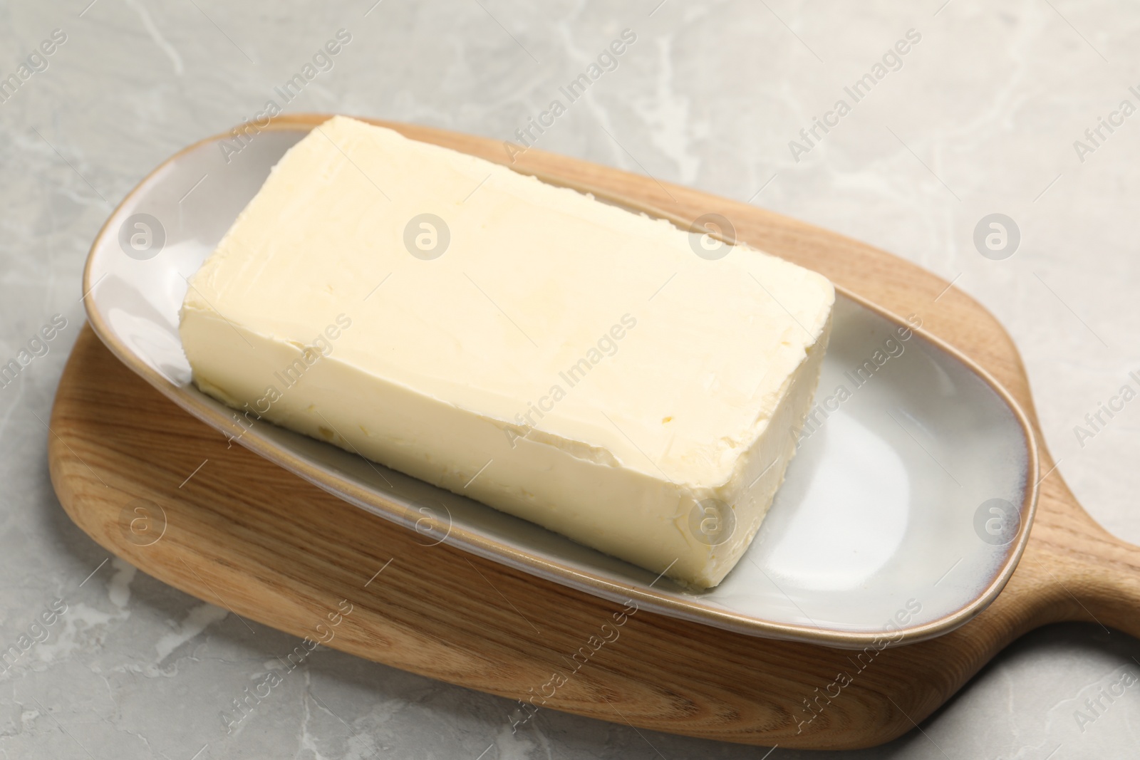 Photo of Block of tasty butter on grey table