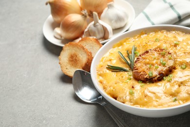 Tasty homemade French onion soup on grey table. Space for text