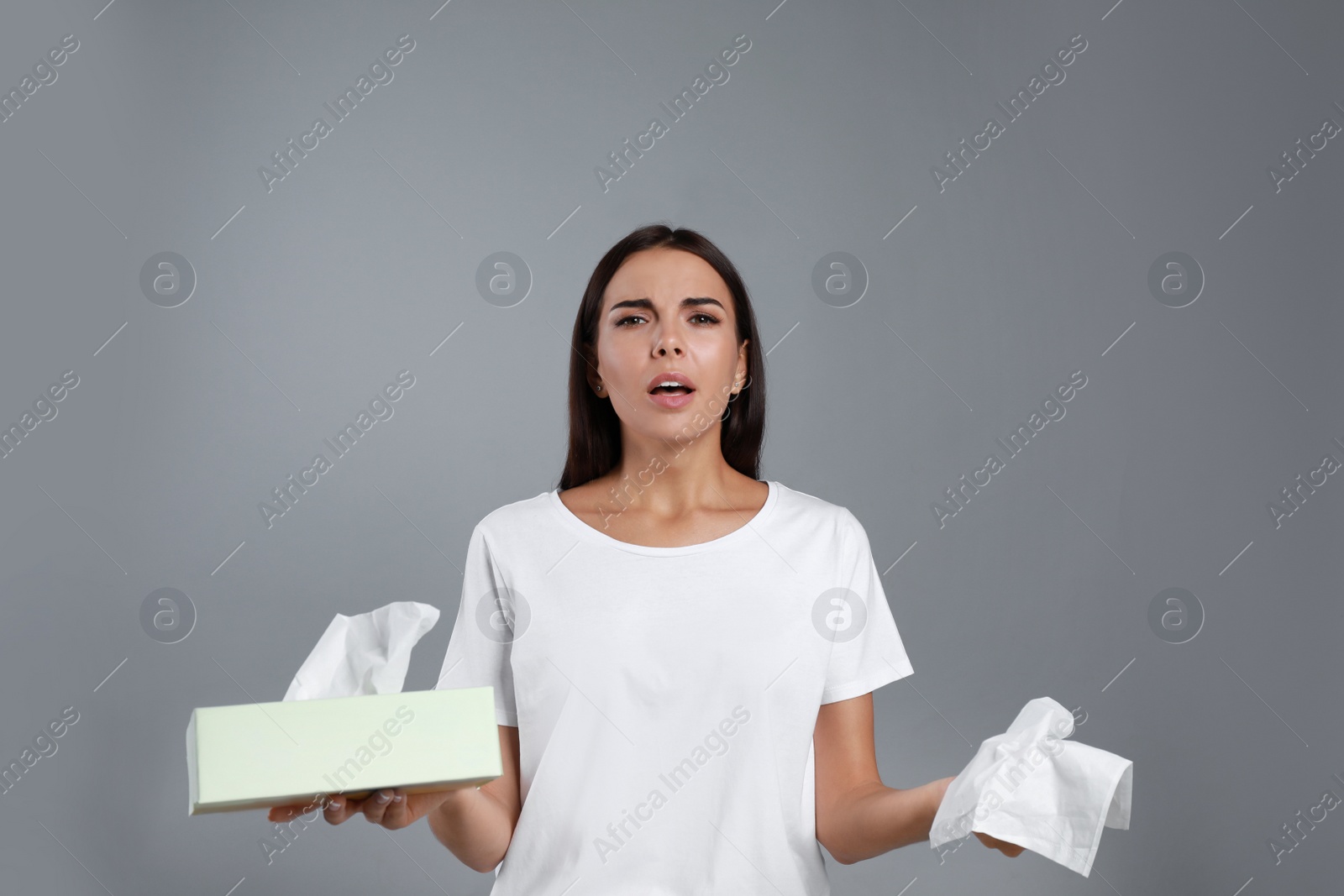 Photo of Young woman suffering from allergy on grey background