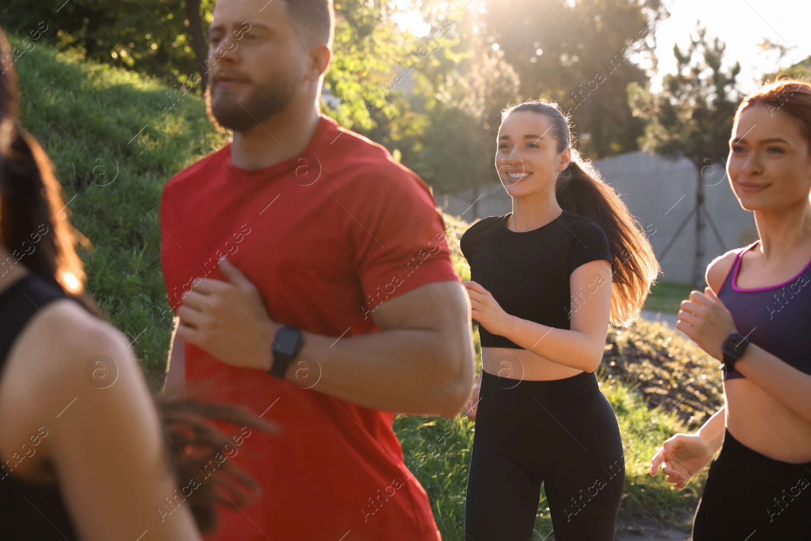 Photo of Group of people running outdoors on sunny day