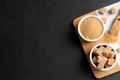 Brown sugar and board on black table, top view. Space for text