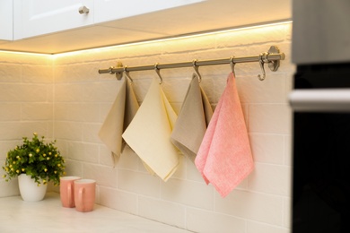 Photo of Clean kitchen towels hanging on wall indoors