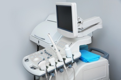 Photo of Modern ultrasound machine against white wall. Diagnostic equipment