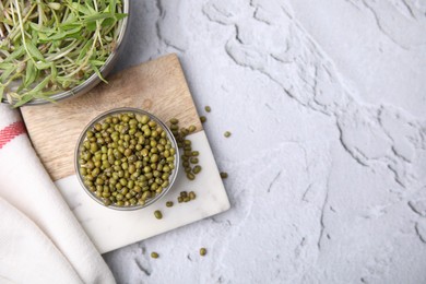 Photo of Glass bowl with mung beans and coaster on white textured table, flat lay. Space for text