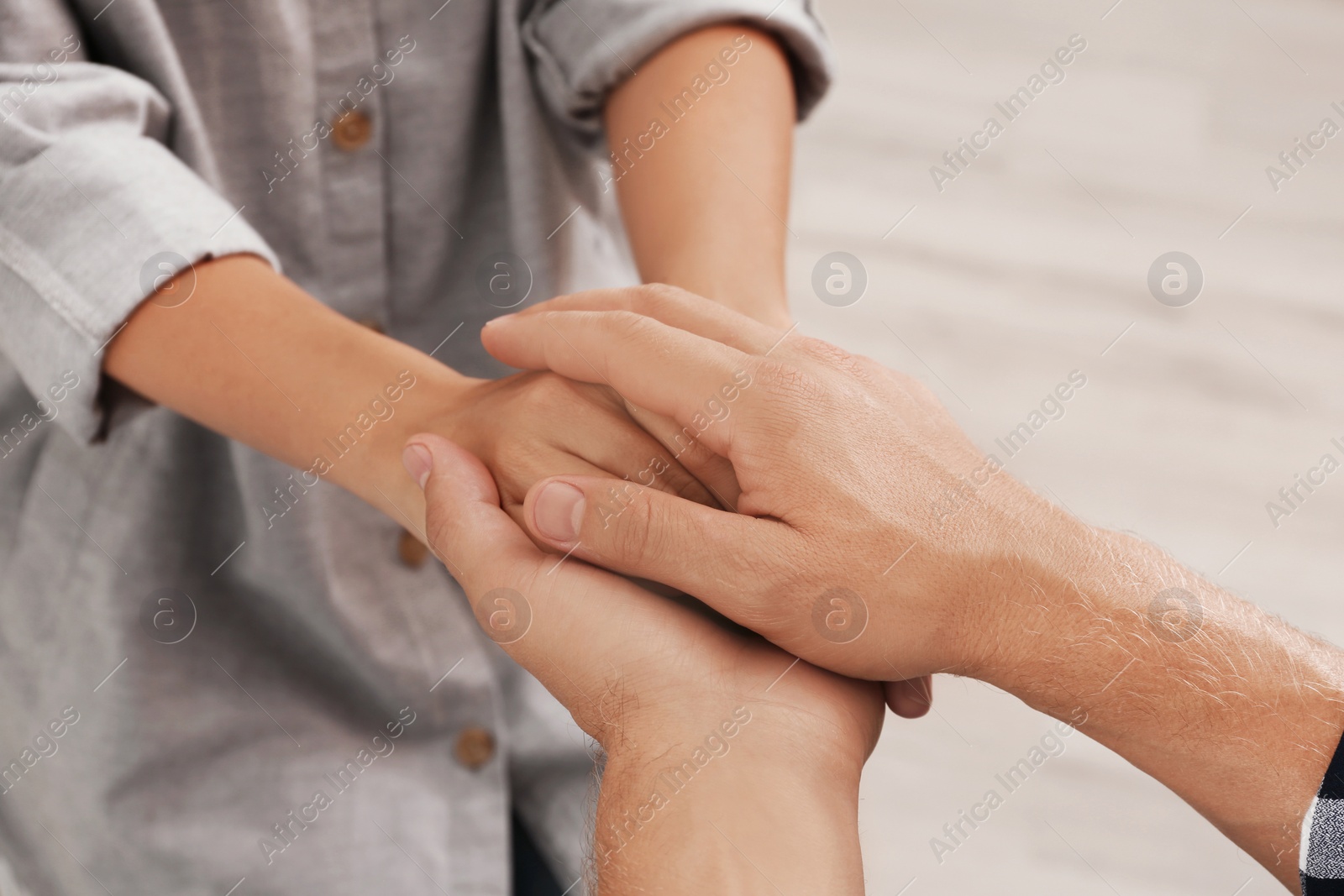 Photo of Man holding woman's hands indoors, closeup. Concept of support and help