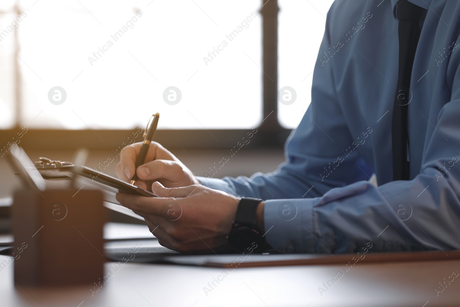 Photo of Male lawyer working at table in office, closeup