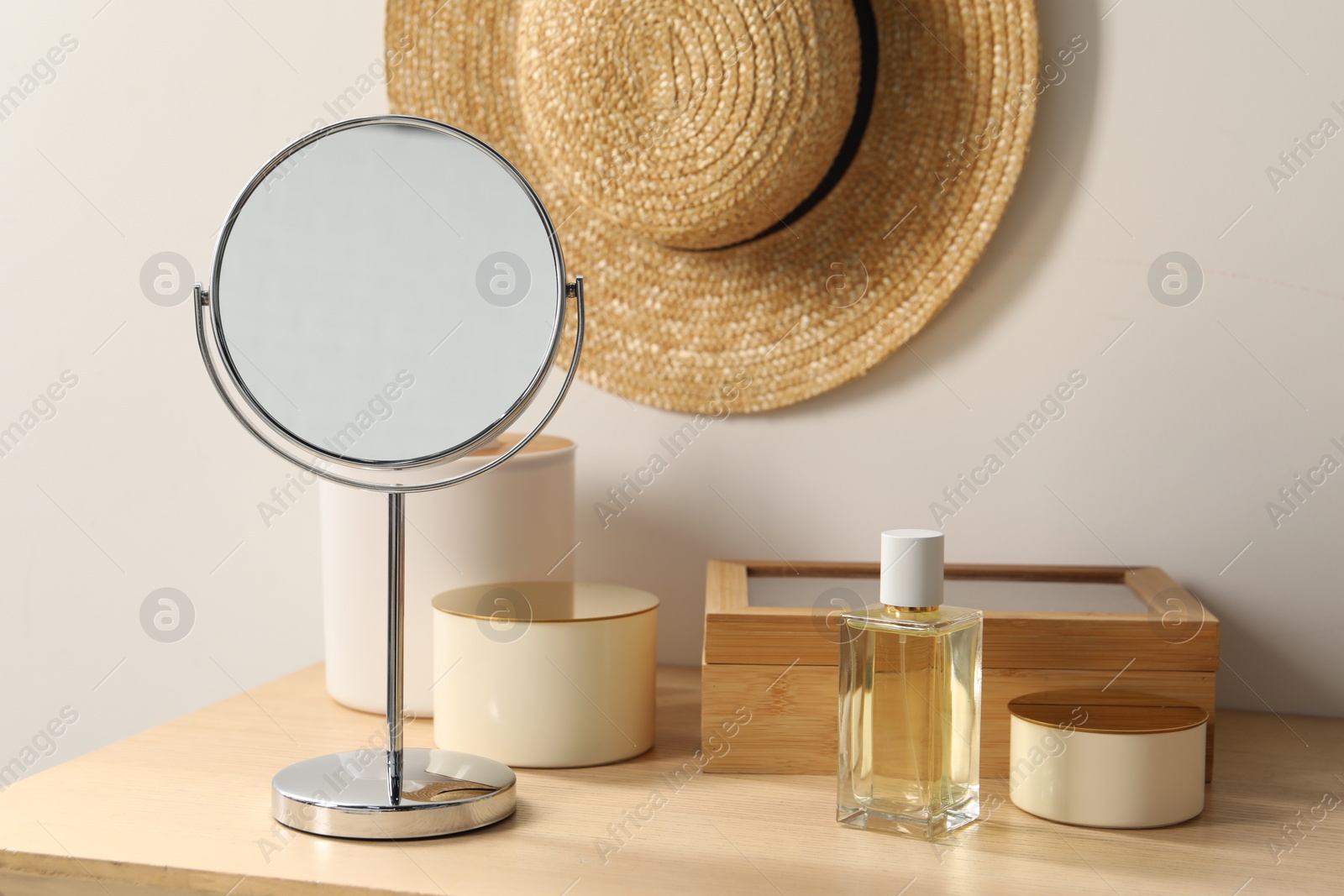 Photo of Mirror, perfume and accessories on makeup table in room