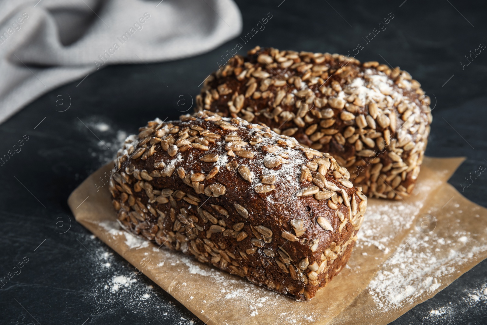 Photo of Fresh wholegrain bread on grey table, closeup