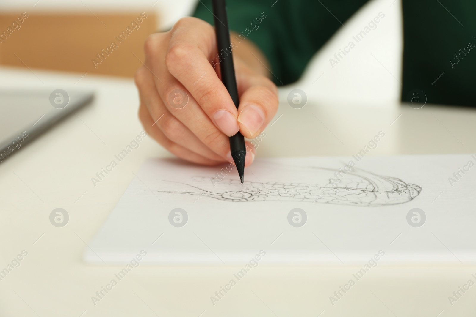 Photo of Woman drawing with pencil in notepad at white table, closeup