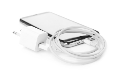 Photo of Smartphone and USB charger on white background. Modern technology