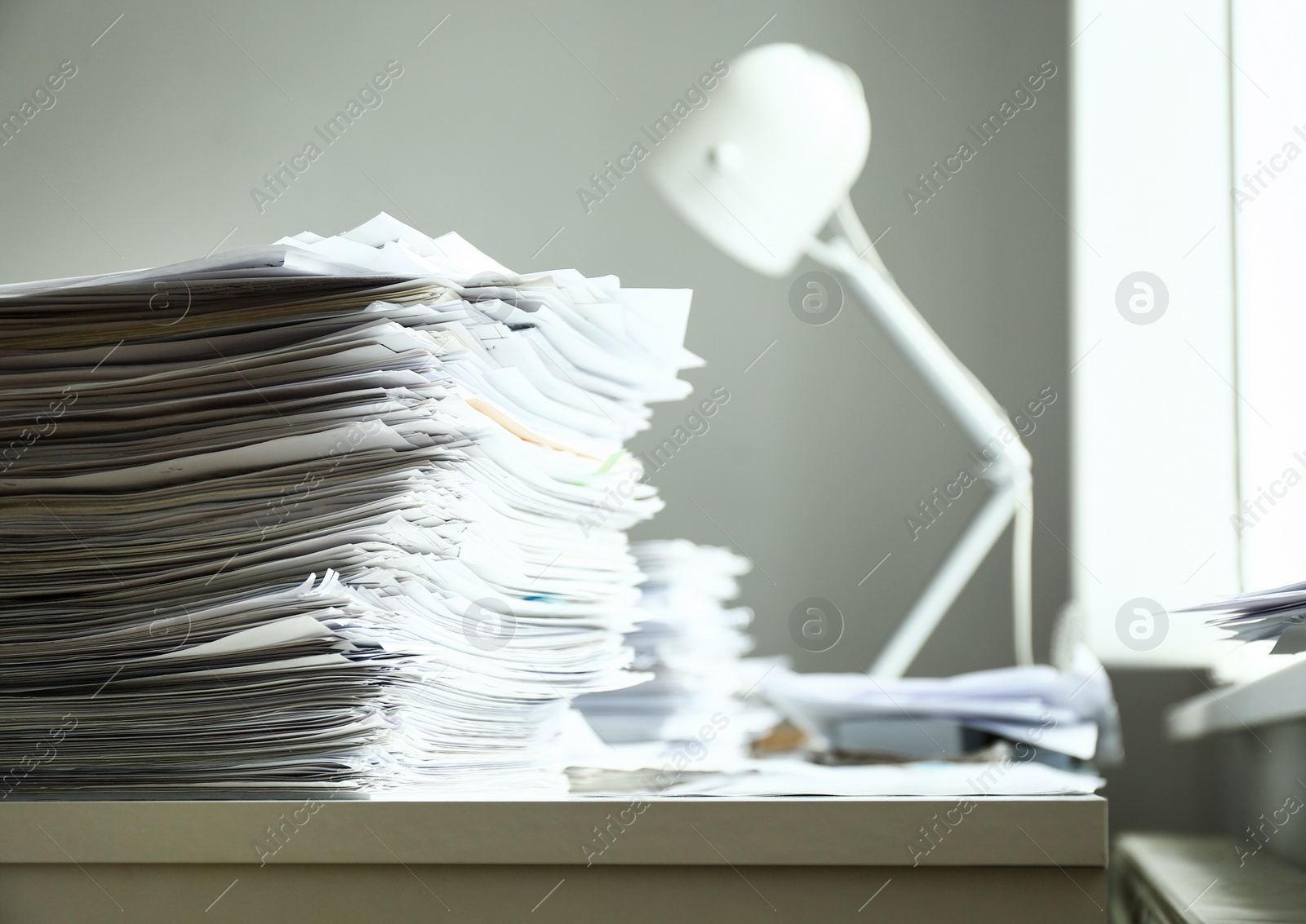 Photo of Stack of documents on desk in office. Space for text