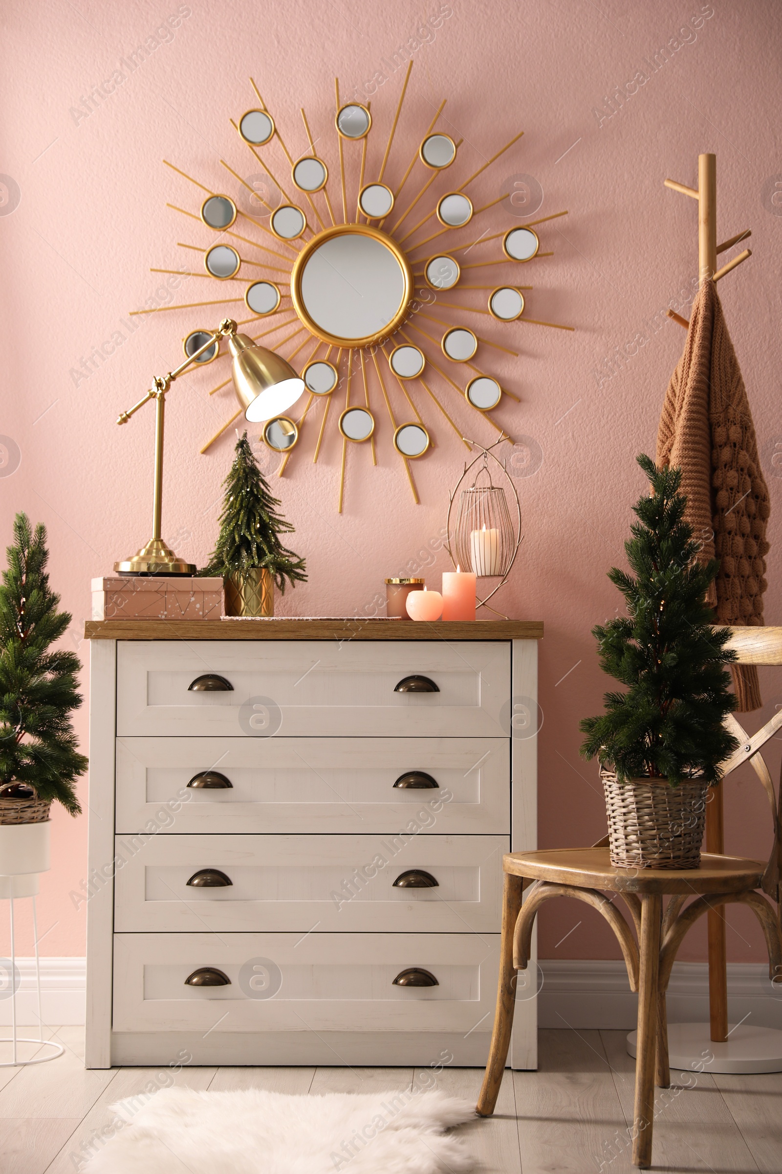 Photo of Stylish room interior with dresser and small fir trees