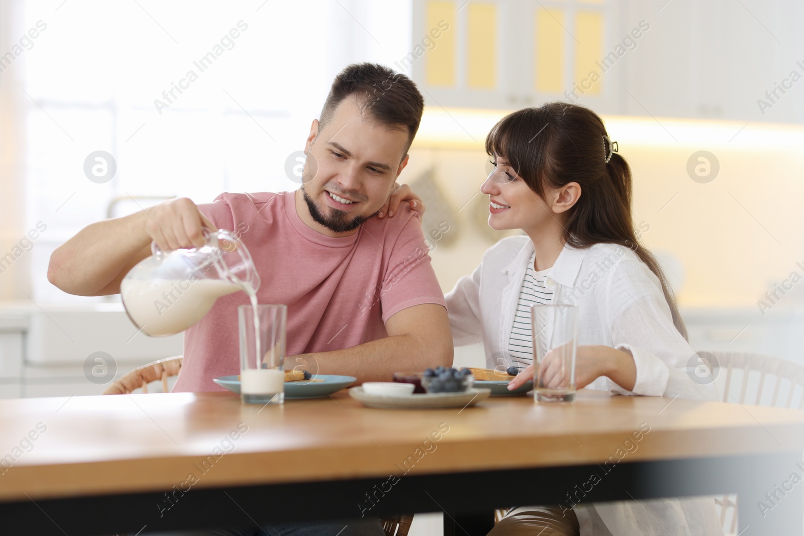 Photo of Happy couple having tasty breakfast at home